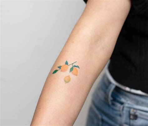 Hand poked lemon branch tattoo on the forearm.