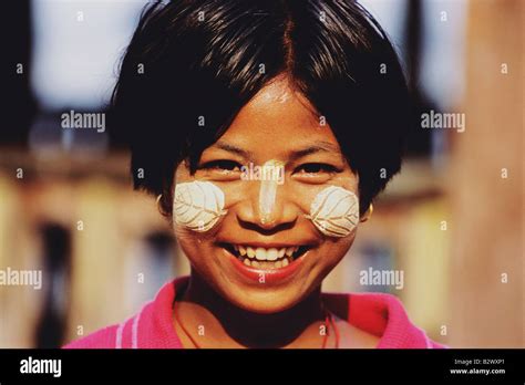 Young girl with traditional makeup as leaf pattern on face made from sandalwood to protect from ...