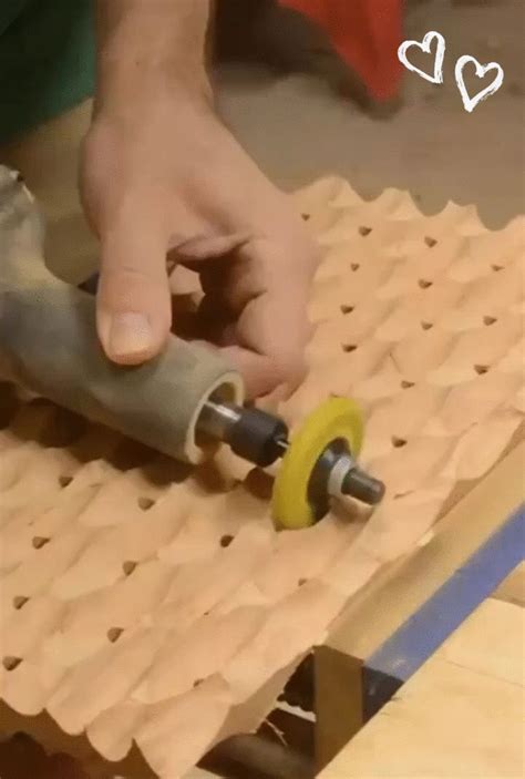 a person using a drill to make a piece of wood