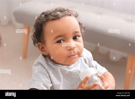 African-American baby with bottle of water at home Stock Photo - Alamy