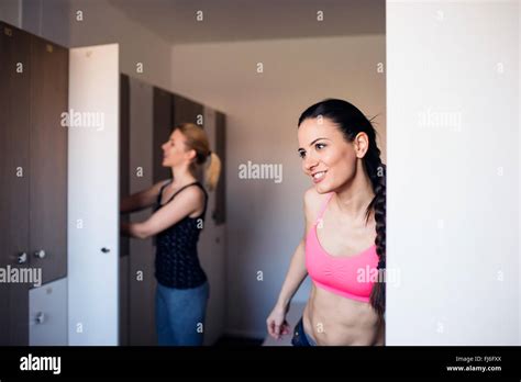 Two woman changing in locker room in gym Stock Photo - Alamy