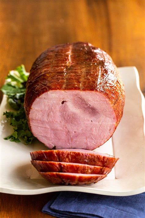 a ham on a plate with parsley next to it