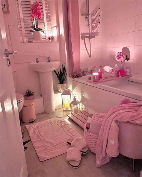 a white bathroom with pink decor and accessories on the floor, along with a bathtub