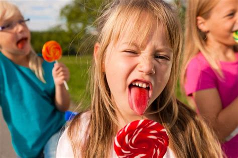 Three girls eating lollipops, the - Stock Image - Everypixel