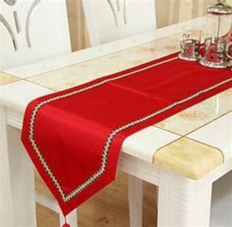 a red table runner on top of a white dining room table