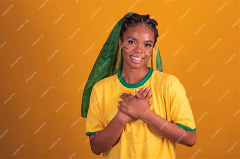 Premium Photo | Young black brazilian woman soccer fan with brazil flag with hand on chest gratitude