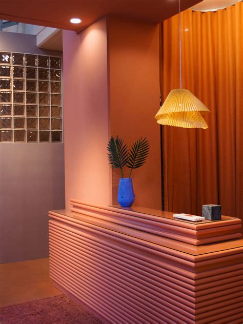 a reception desk with a blue vase on top and a yellow lamp hanging over it