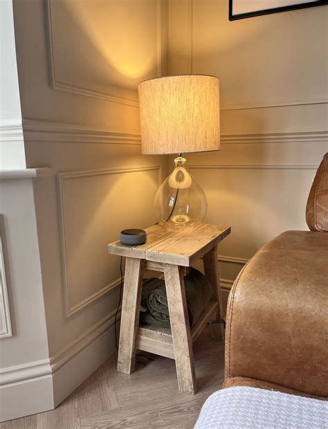 a small wooden table with a lamp on it