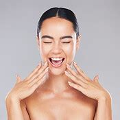 Woman, smile and hands in beauty for skincare, cosmetics or makeup treatment against a grey ...