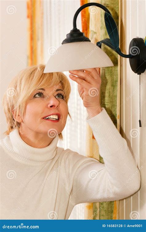 Woman Changing A Light Bulb Stock Photo | CartoonDealer.com #16583100