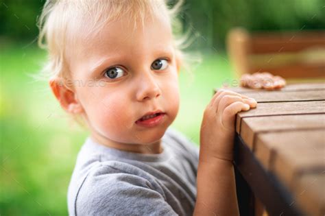 Portrait of little boy standing near table outdoor Stock Photo by leszekglasner