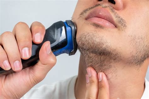 Close Up of a Young Man Shaving with Electric Razor Stock Photo - Image of gray, indoors: 157024668