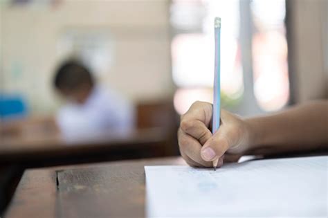 Premium Photo | Small school boy writing homework from school in workboo