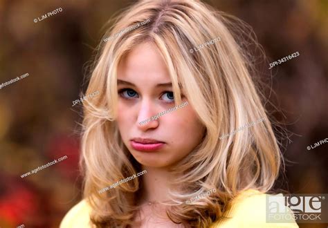Portrait of a beautiful young teenage girl with a big frown on her face; St, Stock Photo ...