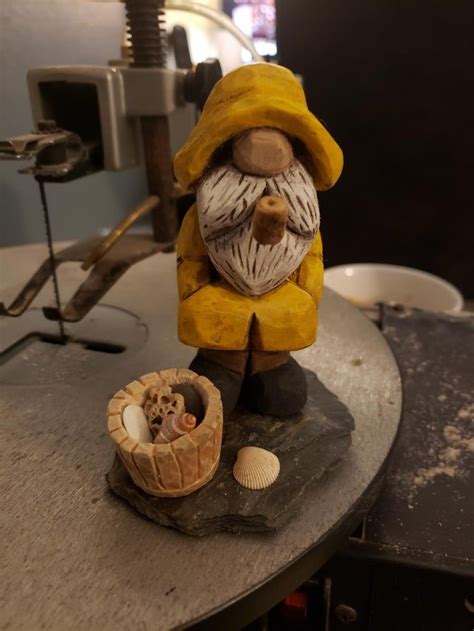 a statue of an old man with a hat and coat sitting on top of a table