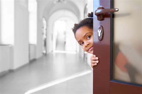 Child Holding Door Open At School