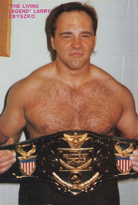 a man with no shirt holding a wrestling belt in front of his face and chest