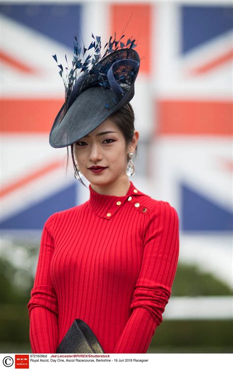 a woman in a red sweater and hat with an union jack flag on the wall behind her