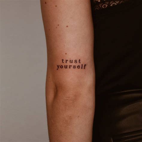 "Trust yourself" lettering tattoo on the tricep.