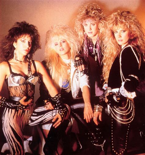 four women dressed in punk clothing posing for a photo together with one woman holding her hand ...