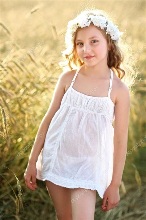 Portrait of a beautiful little girl in a field Stock Photo by ...