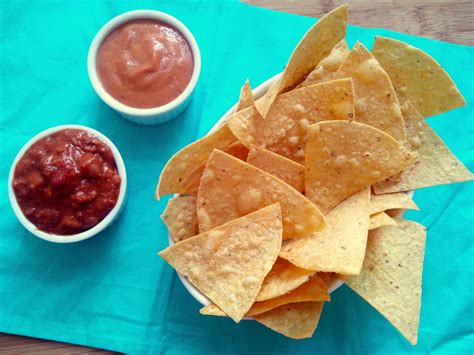 tortilla chips and salsa are on a blue napkin
