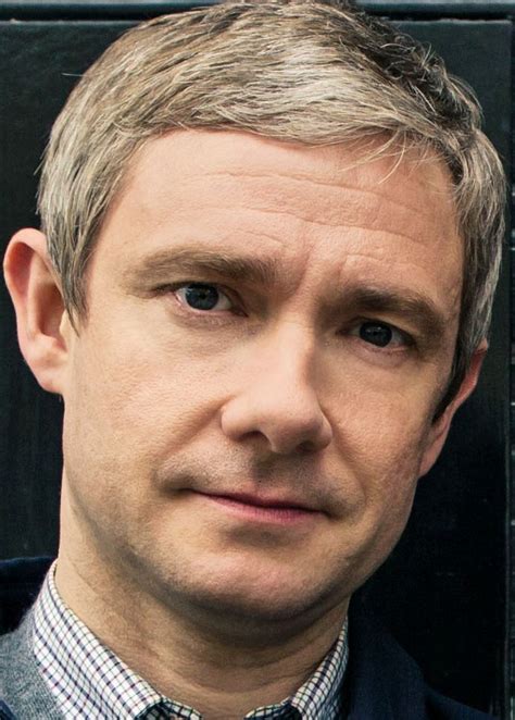 a close up of a person wearing a blue shirt and tie with a black background