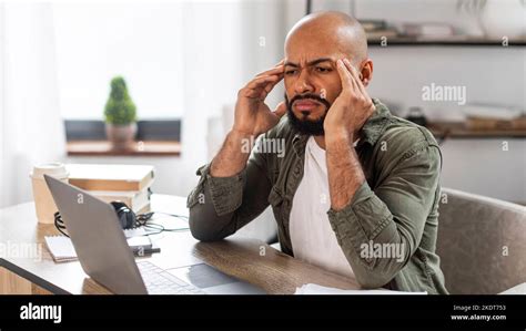 Freelance stress. Tired mature latin man looking at laptop screen and