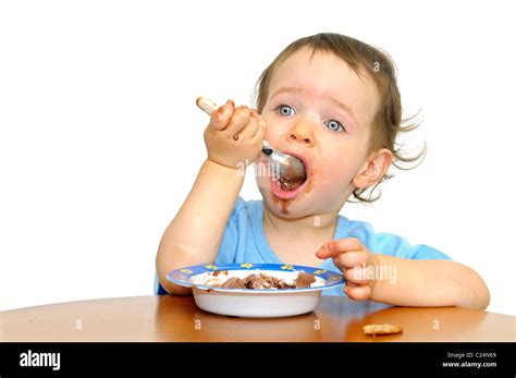 Beautiful blue eyed baby eating icecream with a spoon isolated in white ...