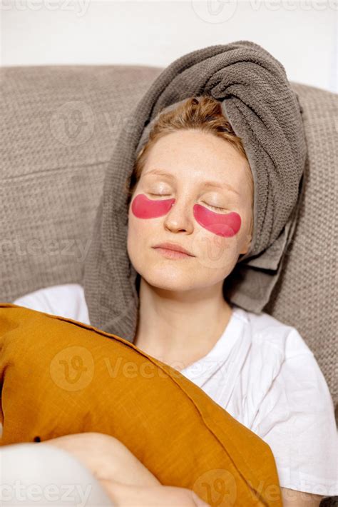 Young woman with casual clothes, towel on head and eye patches sitting