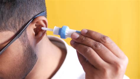 Young man cleaning his ear with cleaning equipment 23288194 Stock Video at Vecteezy