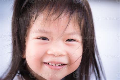 Headshot adorable Asian little child girl sweet smile. Kid has anterior