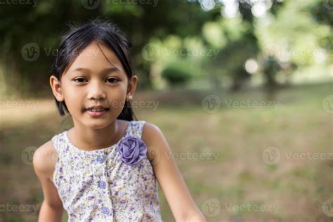 Little cute asian girl standing among the purple flower field sunshine