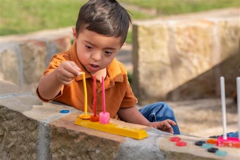 Criança Com Deficiência Intelectual - Uma criança com deficiência intelectual aprendendo com brinquedos ...