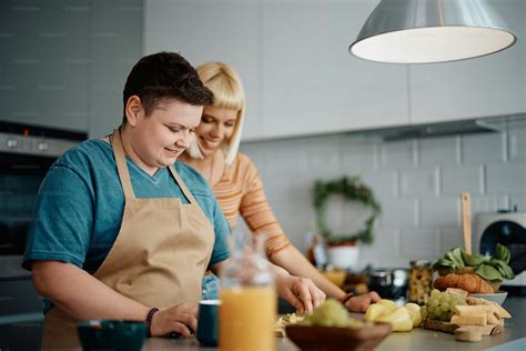 Smiling lesbian enjoying in preparing food with her girlfriend in the