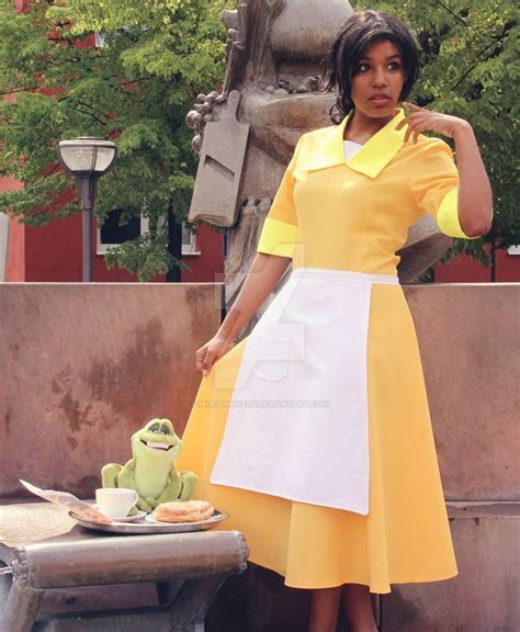 a woman in a yellow and white dress standing next to a statue with a ...