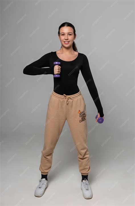 Premium Photo | Young fitness model trains with dumbbells