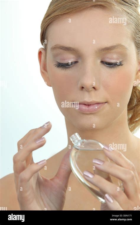 Woman putting on perfume Stock Photo - Alamy