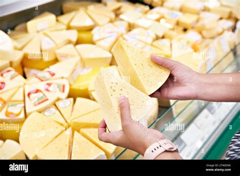 Cheese in the hands of a buyer in a store Stock Photo - Alamy