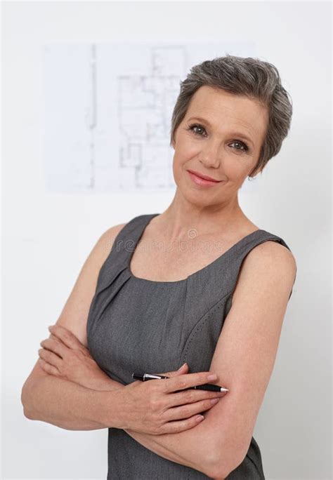 Portrait, Engineer and Confident Mature Businesswoman in Startup with Blueprint on White Wall