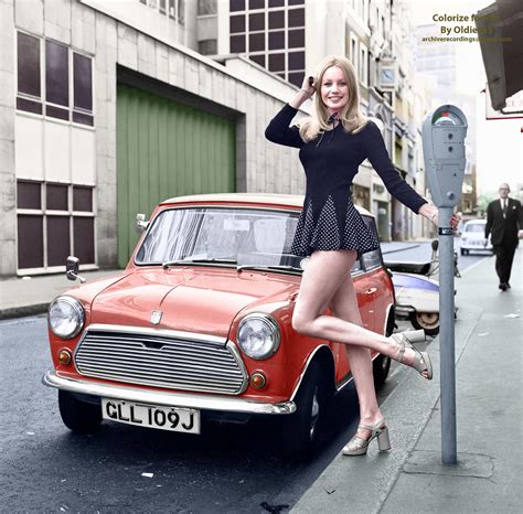British model Jenny Clare poses next to her Mini. London, 1972