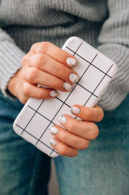 Premium Photo | Stylish blue female nails holding mobile phone ...