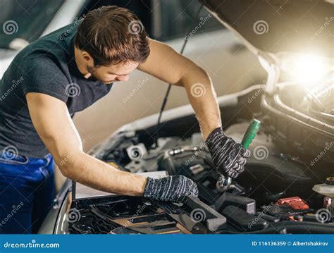 Mechanic Working Under Car Hood in Repair Garage Stock Image - Image of ...