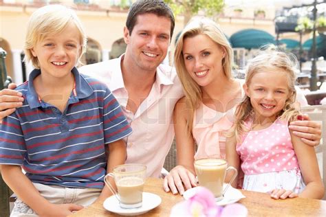 Young Family Enjoying Cup Of Coffee In Caf? Together | Stock image ...