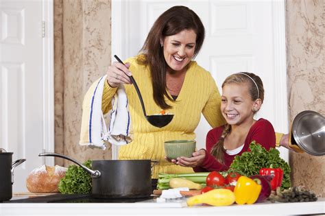 Mother serving daughter soup in kitchen - Mom it ForwardMom it Forward