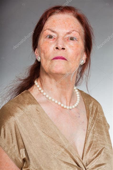 Portrait of good looking senior woman with expressive face showing ...