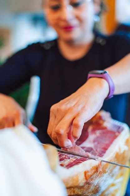 Premium Photo | A woman cuts meat with a knife on a table.