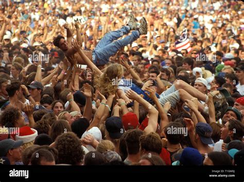 Concert fans are shown being passed around the crowd during Woodstock ...