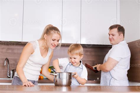 Family mom son, dad are preparing delicious food in kitchen. Mom
