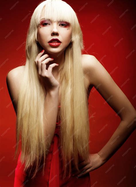 Premium Photo | Perfect blond model in red dress over red background